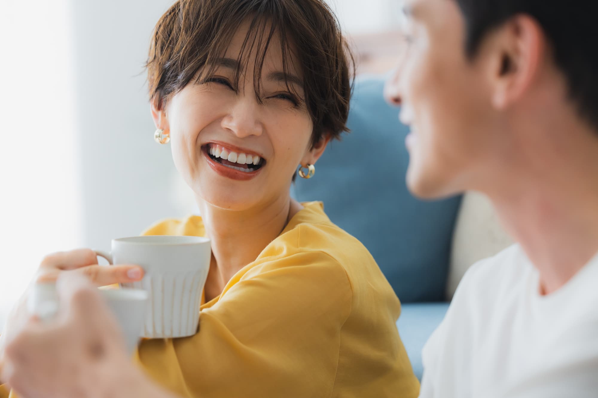 セラミックの歯になり笑顔で会話する女性