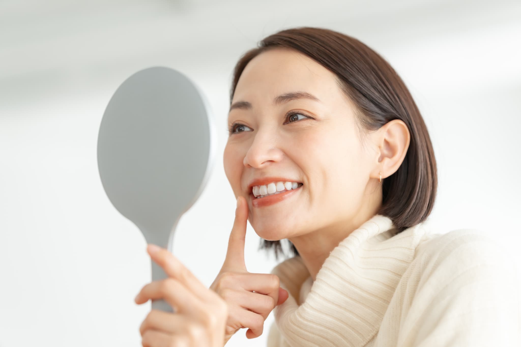 セラミックの歯は着色・変色するのかチェックしている女性