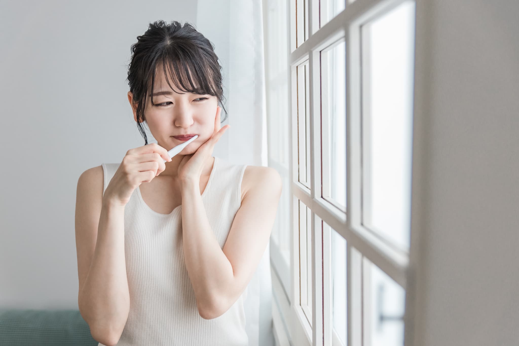 虫歯の初期症状で歯がしみる女性