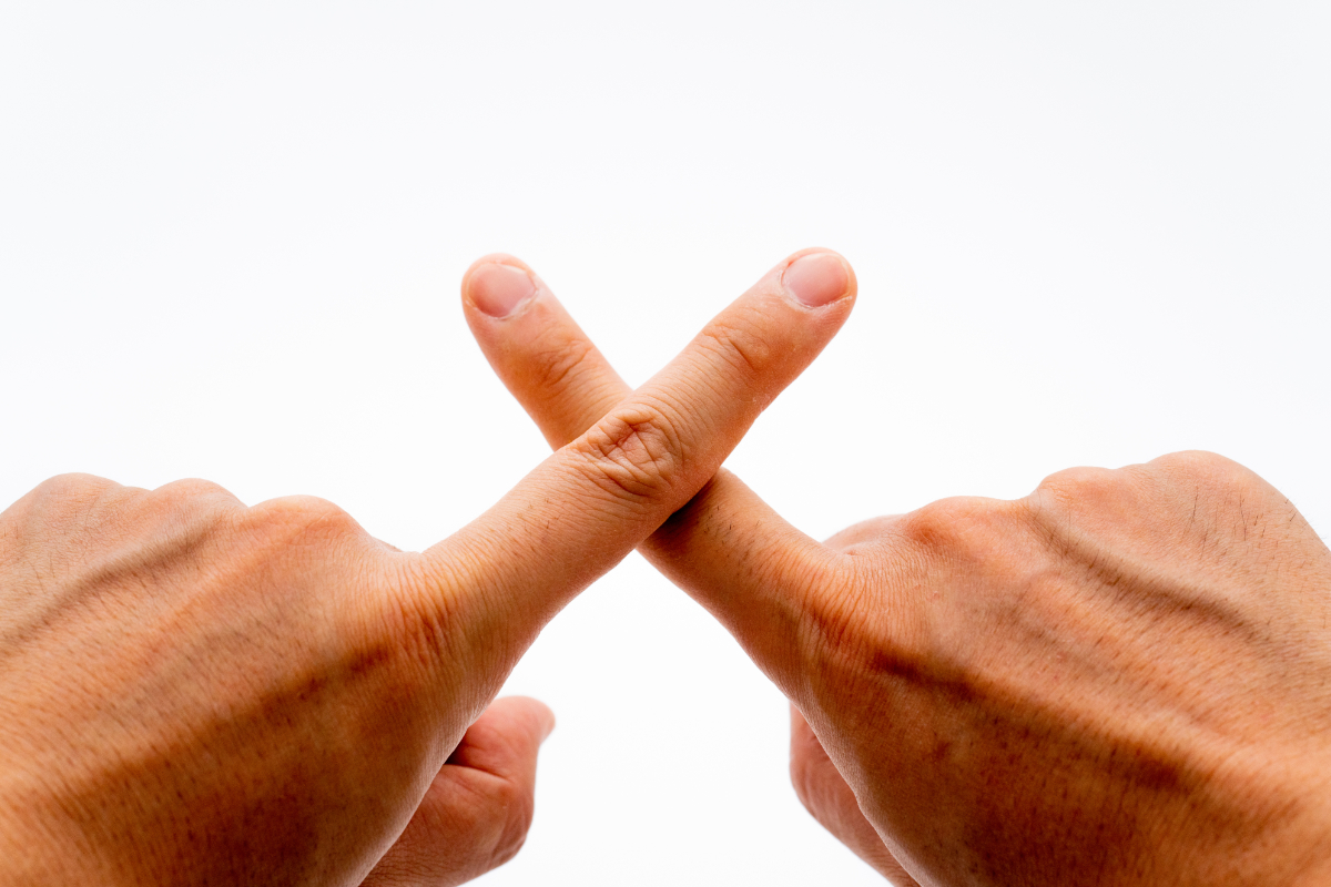2本の指でバツマークを作っている
