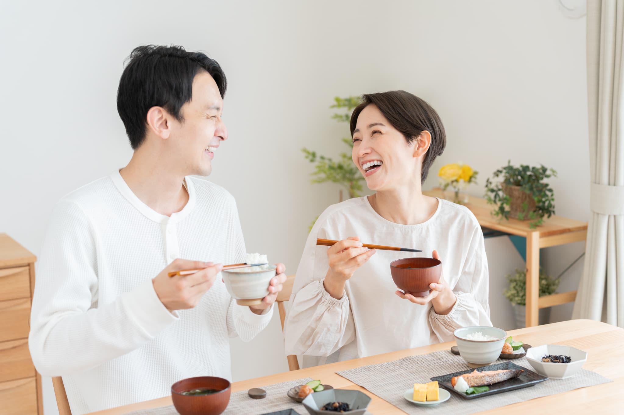 虫歯にならないセラミックの歯で食事する笑顔の夫婦